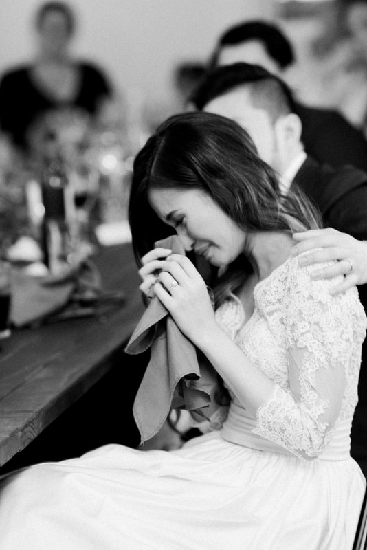 Bride crying while listening to reception speeches